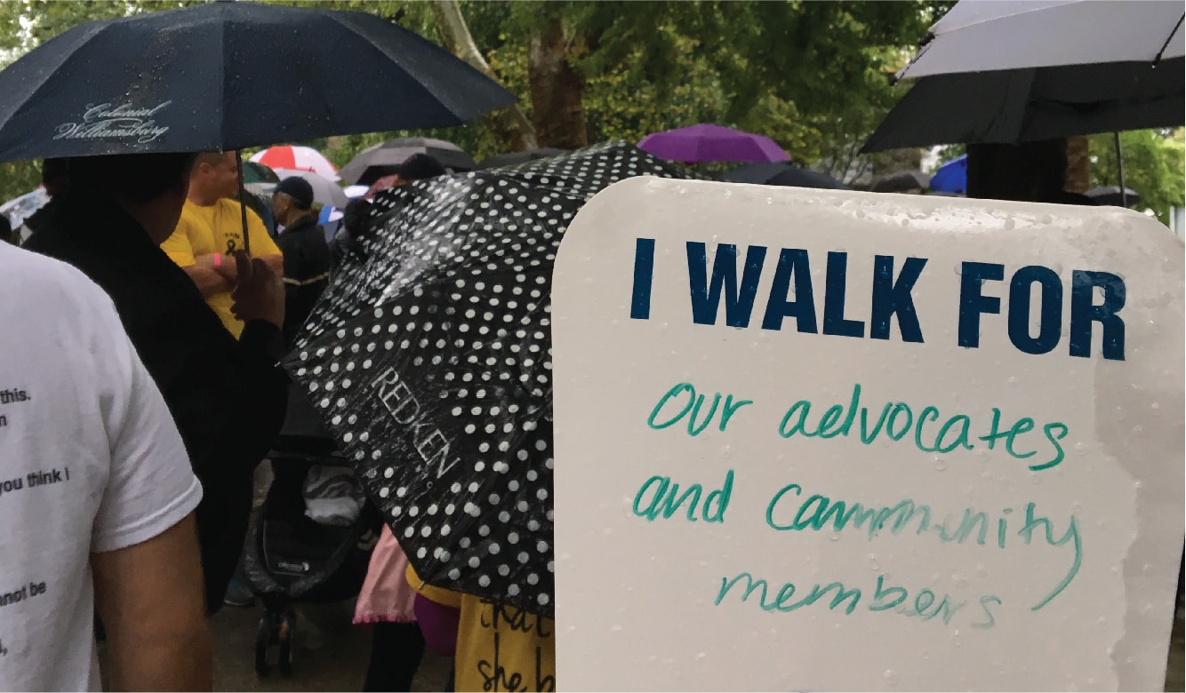 A sign reads, I walk for our advocates and community members