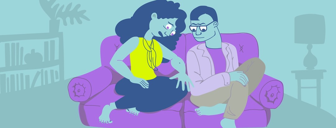a couple sits on a couch and looks at a mole on the woman's arm