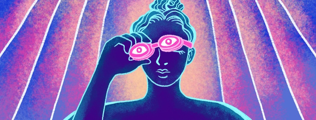 A woman lifts off her goggles inside a tanning bed.