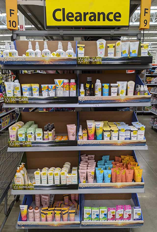 A clearance aisle end cap at a store, filled with a variety of sunscreens.