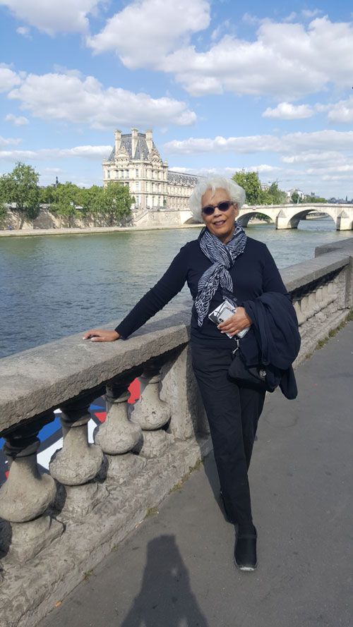 woman stands alongside a body of water