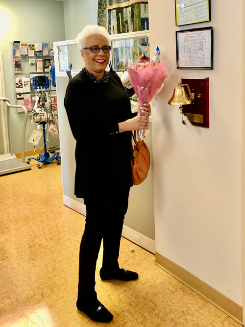 woman is smiling and holding flowers