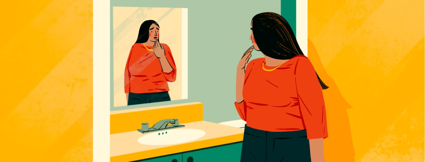 alt=a woman stops at a mirror to examine and worry over a possible skin cancer recurrence on her lip